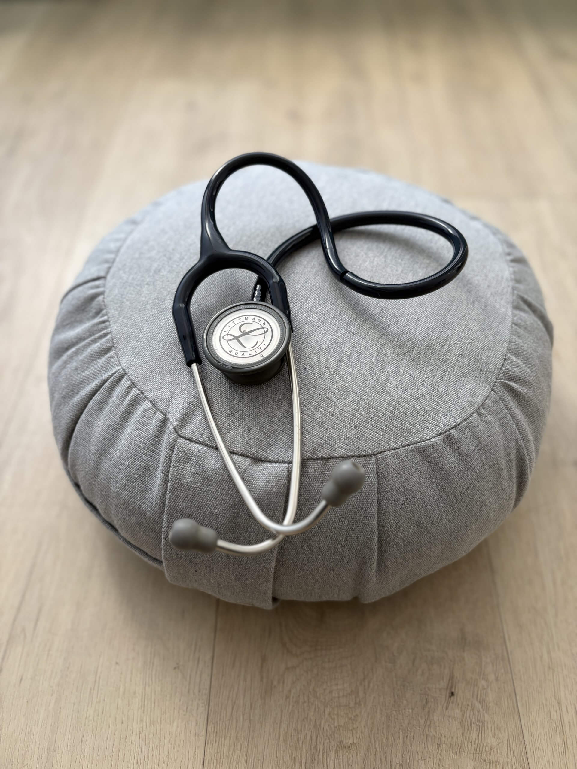 stethoscope sur coussin de méditation gris